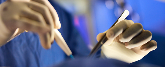 Close-up of surgeons performing excision surgery on a patient with squamous cell skin cancer.