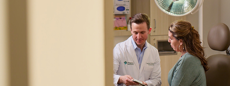 Doctor reviewing diagnosis with patient, discussing options for high-risk skin cancer treatment.