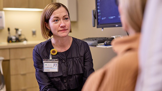 A shot over a patient's shoulder who is talking to an AHN cancer specialist.