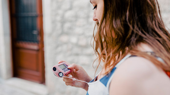 A woman looking at a blood sugar testing device.