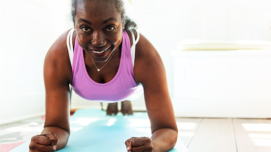 An elderly woman doing the plank stance.