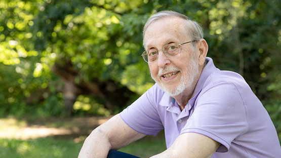 AHN patient Carleton Weber smiling while looking into the camera as he is sitting outside.