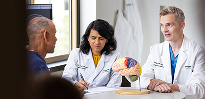 AHN Neuroscience team reviewing a diagnosis with a patient using a model of a brain as a reference tool