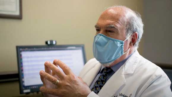 Doctor in office mask talking about epilepsy