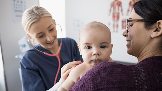 A doctor listening to a baby breathing using a stethoscope.