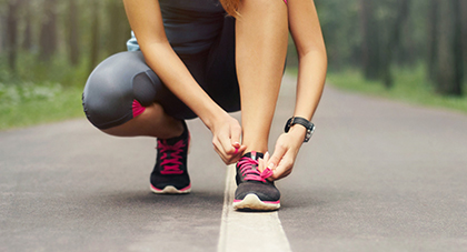 image of a woman tying her shoe for a run