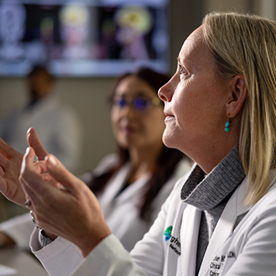 A female medical specialist is looking upwards to the left.