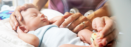 A premature baby being looked after by a nurse in the NICU.