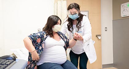 pregnant woman being assisted by a physician during her visit