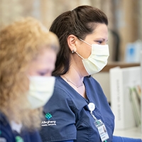 image of a nurse with mask on a computer