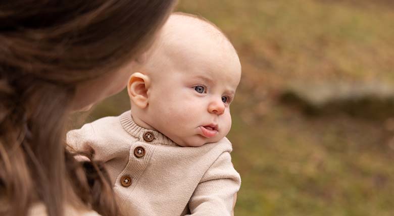 A close-up of AHN Wexford Hospital patient Madison Dischinger holding her newest child in her arms outside.