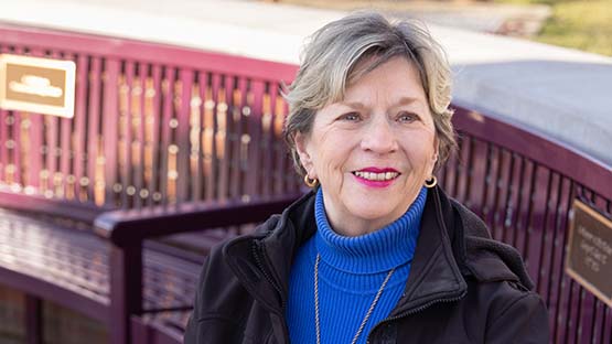 Barbara Lentz is sitting on a bench outside.