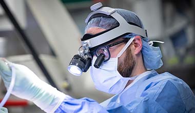 AHN neurosurgeon Dr. Matthew Shepard performing surgery in an operating room.