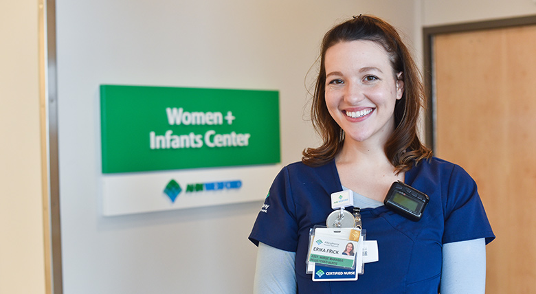 women posing for a picture in front of the womens plus infants center sign