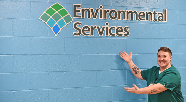 women presenting the AHN environmental services logo sign